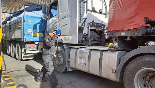 camiones hacen fila para cargar combustible