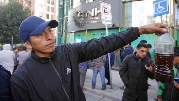 un chofer muestra una botella con gasolina supuestamente de mala calidad