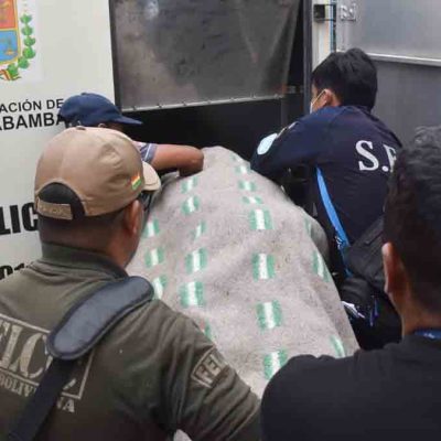 el cuerpo de uno de los fallecidos es introducido al vehículo de Homicidios de la Felcc