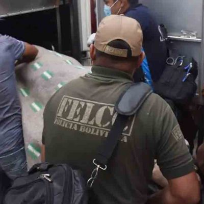 el cuerpo de uno de los fallecidos es introducido en el vehículo de Homicidios de la Felcc