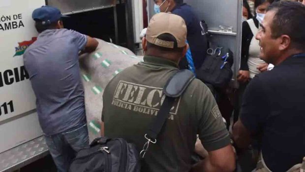 el cuerpo de uno de los fallecidos es introducido en el vehículo de Homicidios de la Felcc