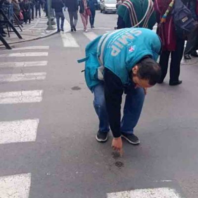 un funcionario municipal muestra el daño provocado en el asfalto por la explosión de dinamita