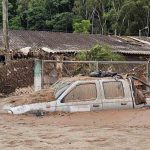 un vehículo atrapado en medio del agua tras el desborde del río en El Trono