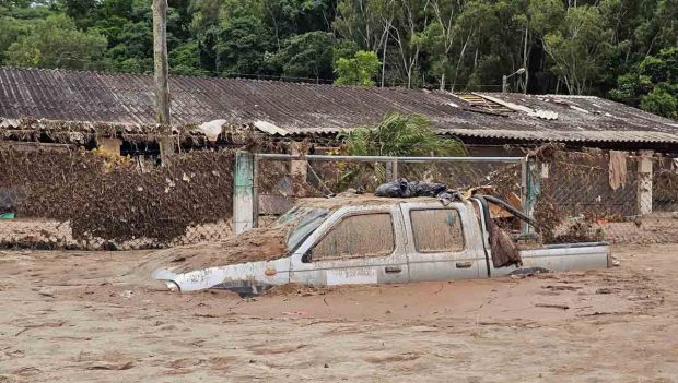 un vehículo atrapado en medio del agua tras el desborde del río en El Trono