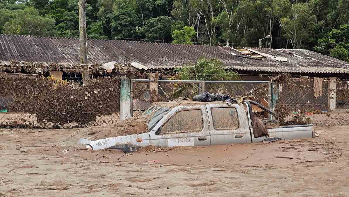 un vehículo atrapado en medio del agua tras el desborde del río en El Trono