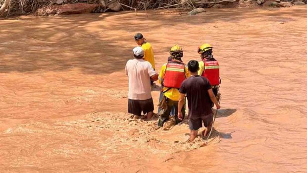 rescatistas buscan los cuerpos de las víctimas arrastradas por la riada