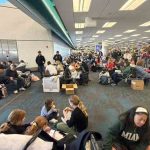 pasajeros de BoA esperan abordar el avión en el aeropuerto de Miami