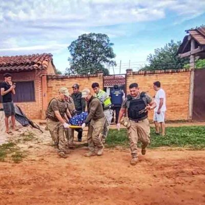policías retiran el cuerpo del acribillado del lugar donde fue asesinado
