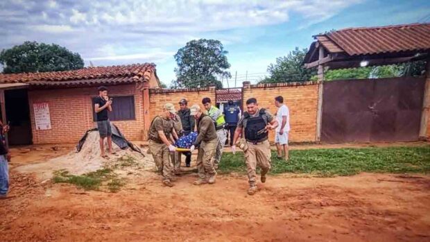 policías retiran el cuerpo del acribillado del lugar donde fue asesinado