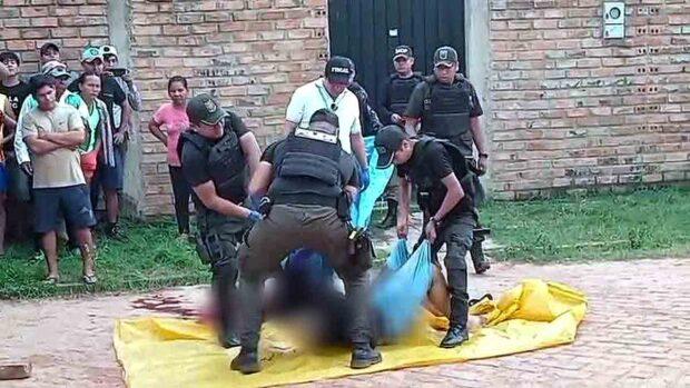 policías realizan el levantamiento del cadáver del hombre acribillado