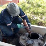 personal de YPFB realiza prueba de calidad de la gasolina en un tanque de almacenamiento
