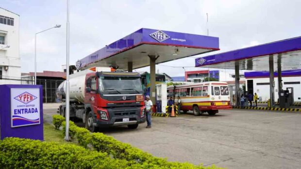 un camión cisterna descarga gasolina en una estación de servicio