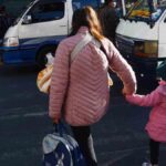 una madre camina con su hija en una calle de La Paz