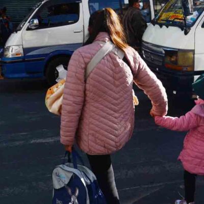 una madre camina con su hija en una calle de La Paz