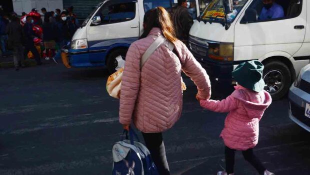 una madre camina con su hija en una calle de La Paz